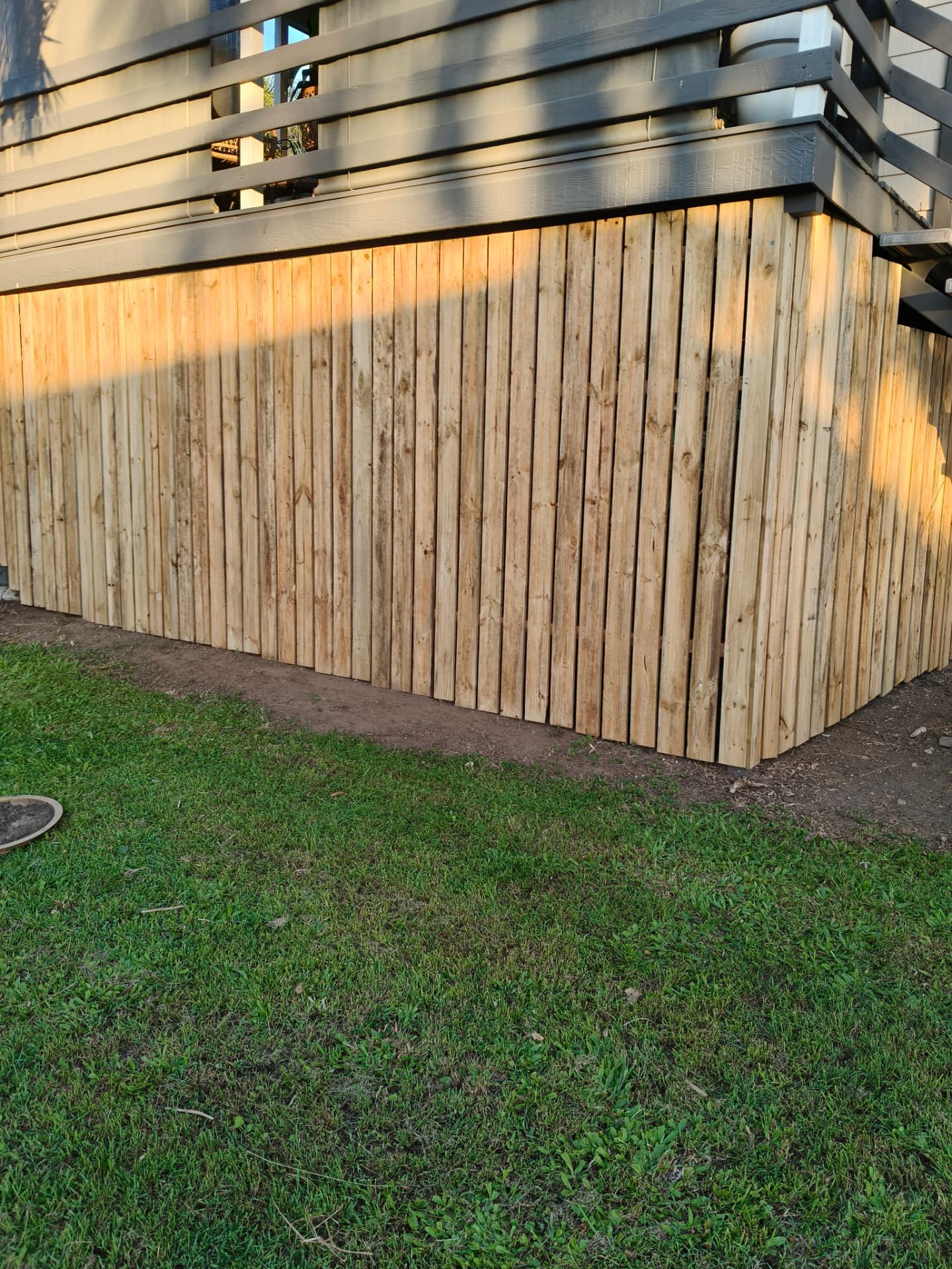 Timber fence with dark privacy screen topper